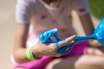 young girl playing with a gooey slime 