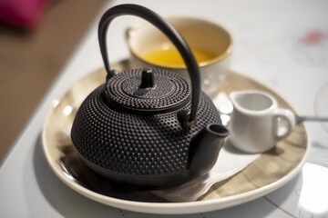 Old style tea set with orientalistic metal tea pot and ceramic cup