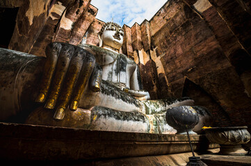 Big buddha image with ruined historical landmark in Sukhothai, Thailand