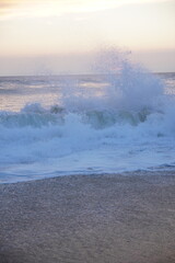 Atardecer en una playa vacia con grandes olas y rojo atardecer