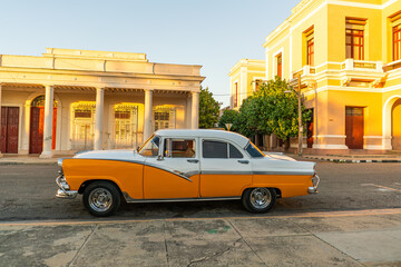 Fototapeta premium beautiful old classic american yellow and white car in cienfuegos old town cuba streets 