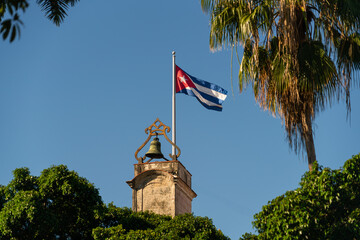 Cuban flag waving on a sunny day on a bell tower of museum city in plaza de armas havana cuba