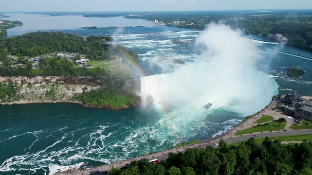 Cinematic drone shot of Horseshoe waterfall with rainbow at Niagara Falls with boat inside in Ontario (Canada) 