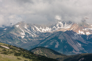 Fototapeta premium Low-lying rain clouds obscure the distant mountains above the treeline within Rocky Mountain National Park, Colorado in mid-July