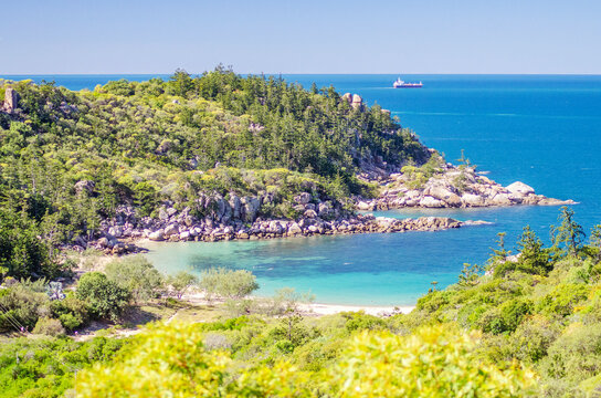 Picturesque golden sandy Arthur Beach with granite boulders and turquoise water on Magnetic Island, Queensland, Australia. The island is a holiday destination 8 km offshore of Townsville.