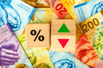 Wooden blocks with bank interest rate percent of bank with Swiss francs, Financial analysis, crisis project or economic growth concept. Switzerland money, close up, Flat lay background