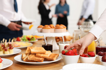 Coworkers having business lunch in restaurant, closeup