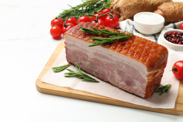 Piece of raw bacon, rosemary and tomatoes on white marble table