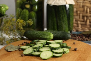 Board with fresh cucumbers and spices on table, closeup
