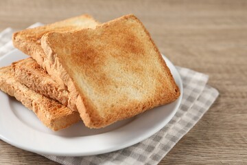 Slices of delicious toasted bread on wooden table, closeup