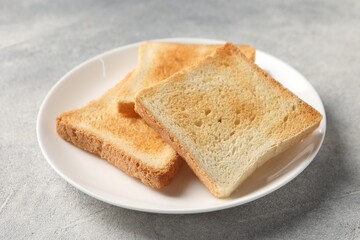 Slices of delicious toasted bread on light table, closeup