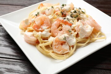 Delicious pasta with shrimps on wooden table, closeup