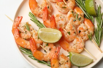 Skewers with delicious grilled shrimps served on white table, top view