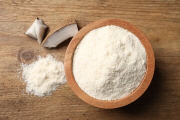 Organic coconut flour in bowl on wooden table, flat lay