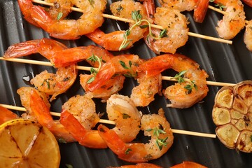 Skewers with delicious shrimps on grill pan, top view