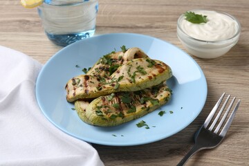 Tasty grilled courgette slices served on wooden table