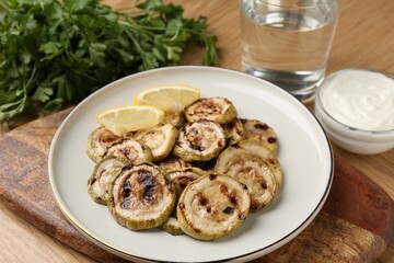 Tasty grilled courgette slices served on wooden table