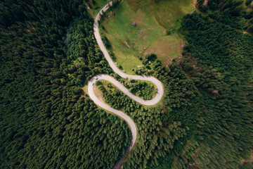 Aerial view of the road passing through the mountain and green forest. Curve asphalt road on mountain.