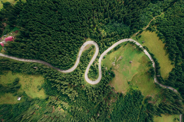 Aerial view of the road passing through the mountain and green forest. Curve asphalt road on mountain.	
