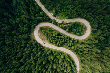 Aerial view of the road passing through the mountain and green forest. Curve asphalt road on mountain.	
