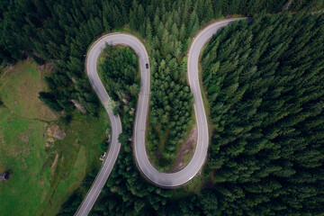 Aerial view of the road passing through the mountain and green forest. Curve asphalt road on mountain.