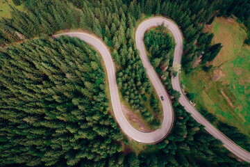 Aerial view of the road passing through the mountain and green forest. Curve asphalt road on mountain.	
