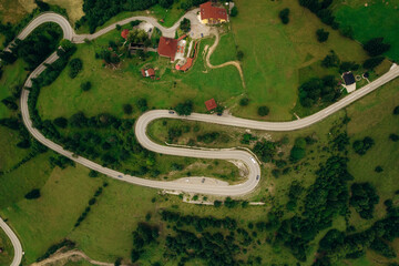 Aerial view of the road passing through the mountain and green forest. Curve asphalt road on mountain.