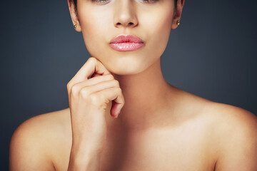 Cosmetics, makeup and lips of girl in studio with kiss, closeup and glossy mouth with healthy glow. Skincare, beauty and woman with natural lipstick color, luxury filler and shine on gray background