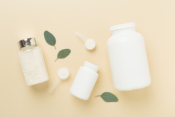 Jars with protein powder on color background, top view. Sports nutrition concept