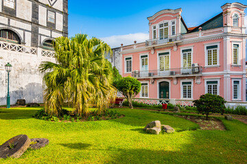 Traditional colonial style architecture with colorful house and small garden in Horta town, Faial...