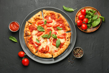 Delicious Margherita pizza and ingredients on black table, top view