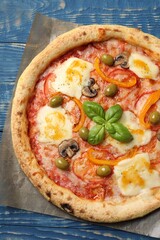 Delicious vegetarian pizza on blue wooden table, top view