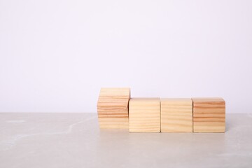 Wooden cubes on light table against white background. Space for text