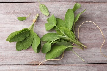 Green sage leaves on color wooden table, flat lay