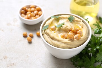 Delicious hummus with olive oil and chickpeas on light table