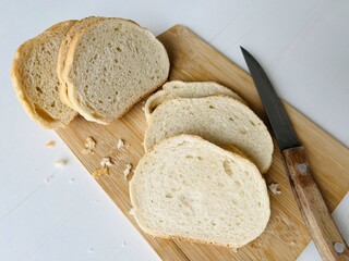 Loaf of bun. Sliced bread on a cutting board with a knife on a white background