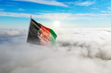 Afghanistan flag aerial view in beautiful sky with clouds. Top-down drone shot at sunrise or sunset. Aerial bird's eye view of the flag with cloudscape.