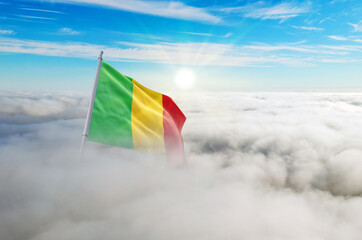 Mali flag aerial view in beautiful sky with clouds. Top-down drone shot at sunrise or sunset. Aerial bird's eye view of the flag with cloudscape.