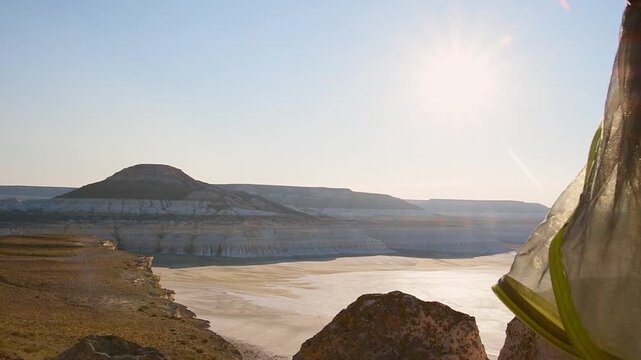 Camping first person point of view enjoy coffee and sunrise in Sor Tuzbair - most spectacular natural wonders of Mangystau. Salt flats, chalky hills and limestone cliffs in hot summer morning