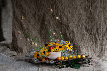 Fototapeta premium floral composition of wildflowers using cherry plum fruits and bird feathers. naturalistic style.