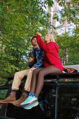 Adventurous Couple Resting On Van Roof