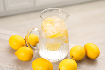 Freshly made lemonade in jug on white wooden table