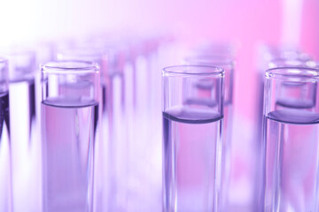 Many glass test tubes on color background, closeup