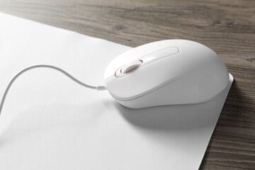 Wired mouse and mousepad on wooden table