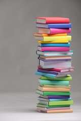 Stack of colorful books on light grey background