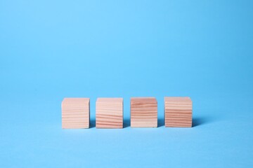 Many blank wooden cubes on light blue background
