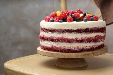 Tasty sponge cake with different fruits on wooden surface
