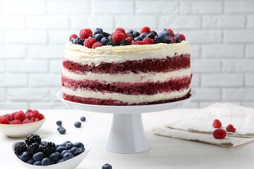 Tasty sponge cake with different berries on white wooden table