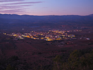 Obraz premium Adzaneta del Maestre, a village in El Maestrazgo, in the Province of Castellón, Spain, illuminated at night, from the mountains of El Bovalar