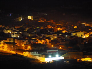 Obraz premium Adzaneta del Maestre, a village in El Maestrazgo, in the Province of Castellón, Spain, illuminated at night, from the mountains of El Bovalar